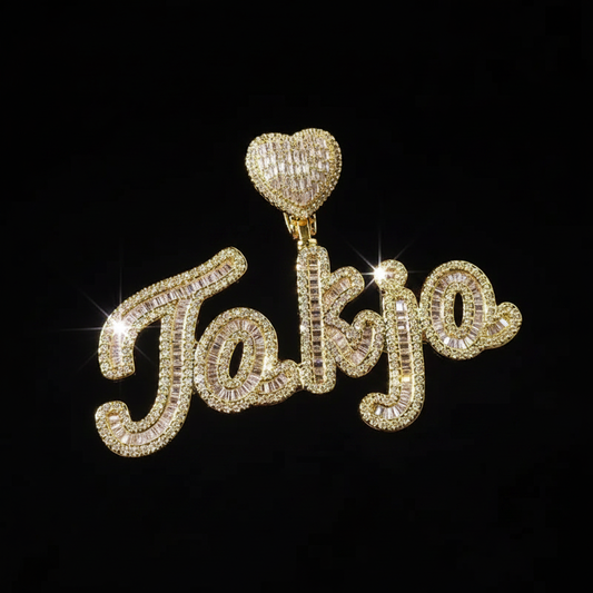 Gold iced-out baguette cursive name pendant — dense pavé CZ setting that defines the iced out look in hip-hop jewelry