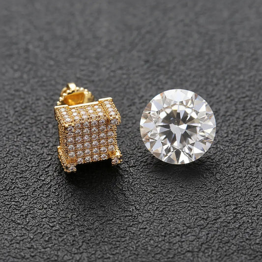 Gold iced-out CZ square stud earrings next to a loose diamond on dark background — CZ vs diamond comparison
